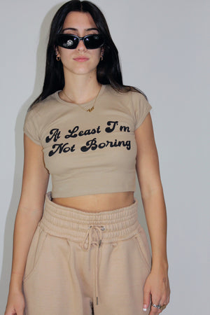 At Least I'm Not Boring Crop Baby Tee in Hazlenut